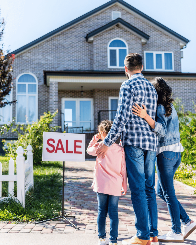 a family standing outside of their home that's for sale with a VA assumable mortgage