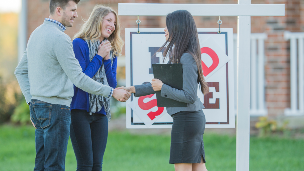 A couple is shaking their realtor's hand after purchasing an assumable mortgage home. 