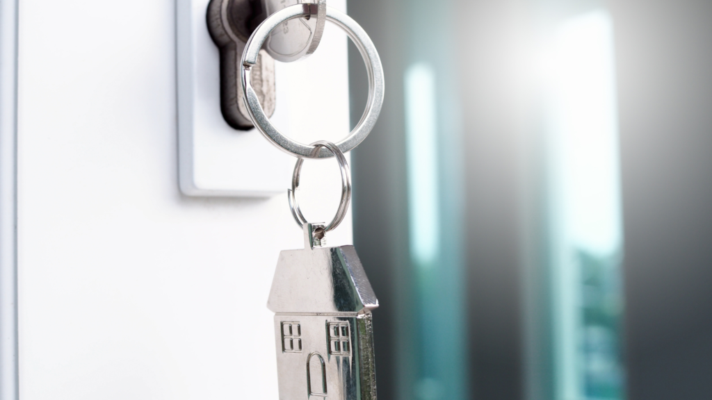 A set of house keys are hanging in the door lock of a new FHA assumable mortgage home. 