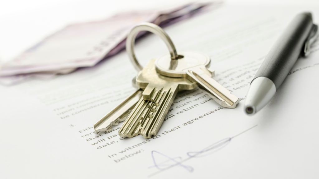 A pen and set of house key are lying on top an agreement to purchase an FHA assumable mortgage home. 