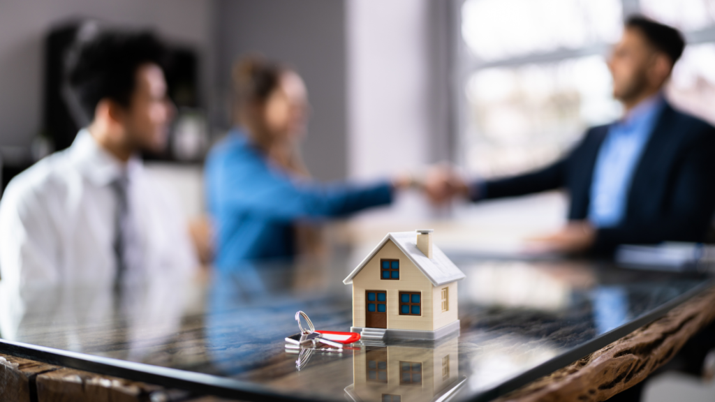 A couple is shaking hands with a realtor after purchasing a home with an assumable mortgage. 