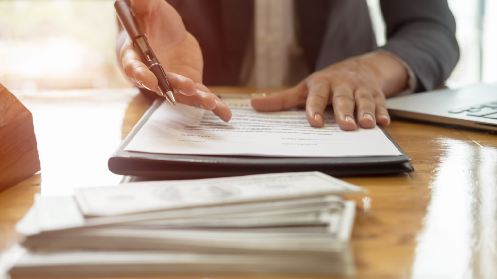 FHA assumable mortgage paperwork being signed at a desk. 