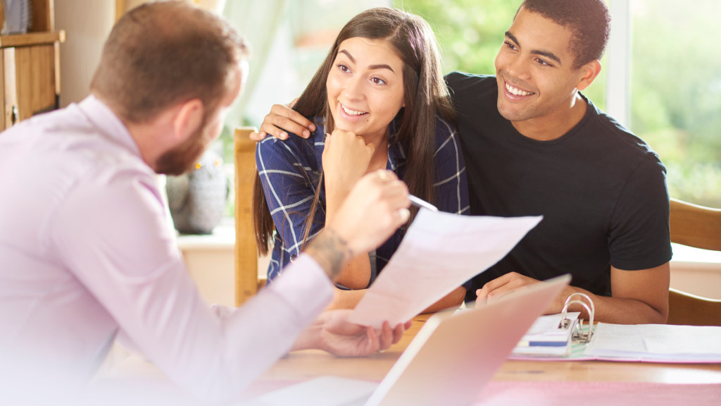 An eager couple is signing VA mortgage loan paperwork to purchase a home. 